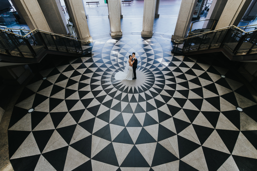 Couple at the centre of a black and white mosaic floor